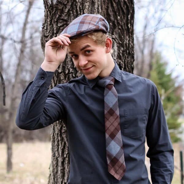 A young man wearing an OUTLANDER Golf Cap Authentic Premium Wool Tartan and plaid shirt.